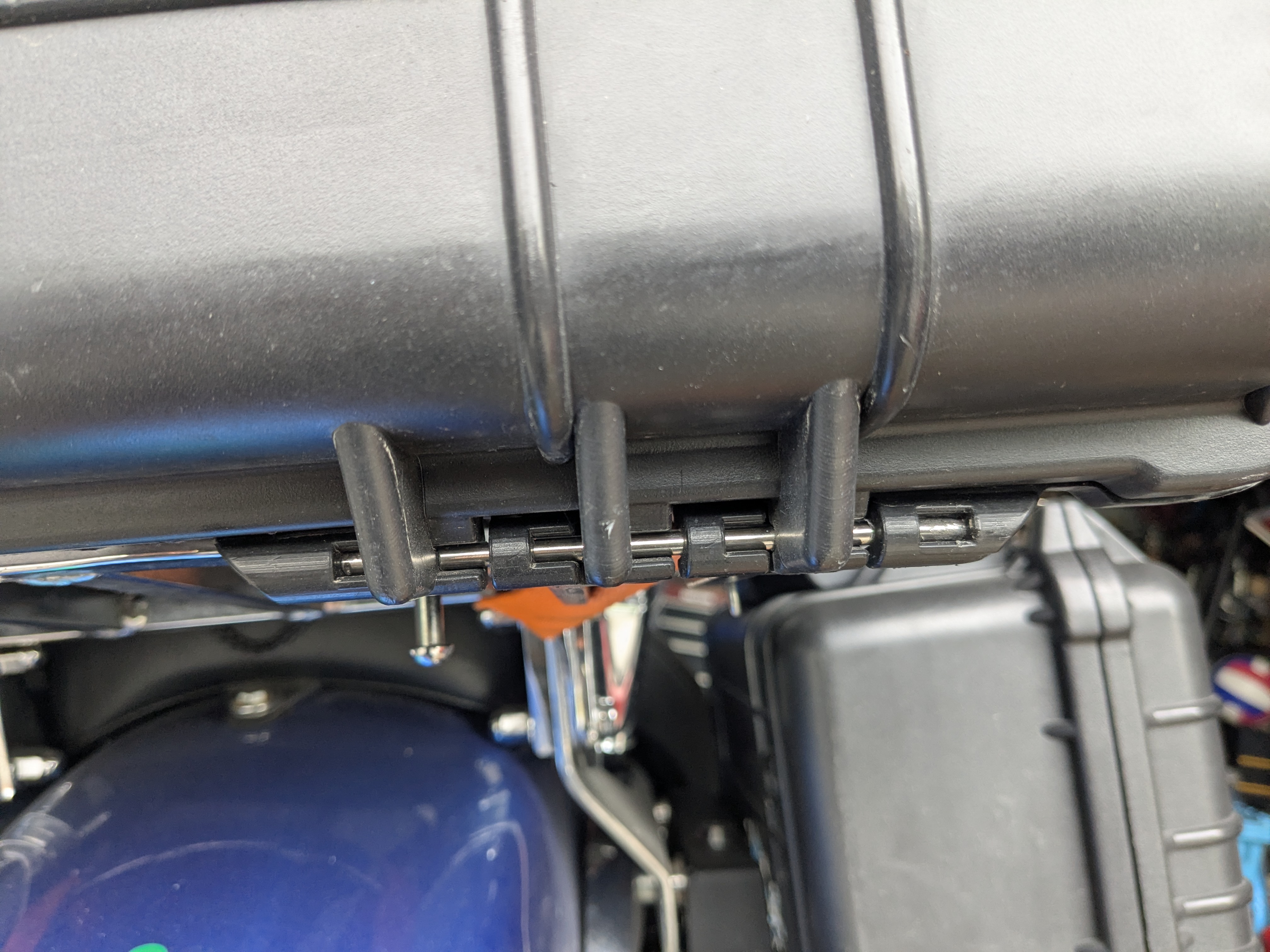 Factory hinge area showing the original hinge pin arrangement before modification