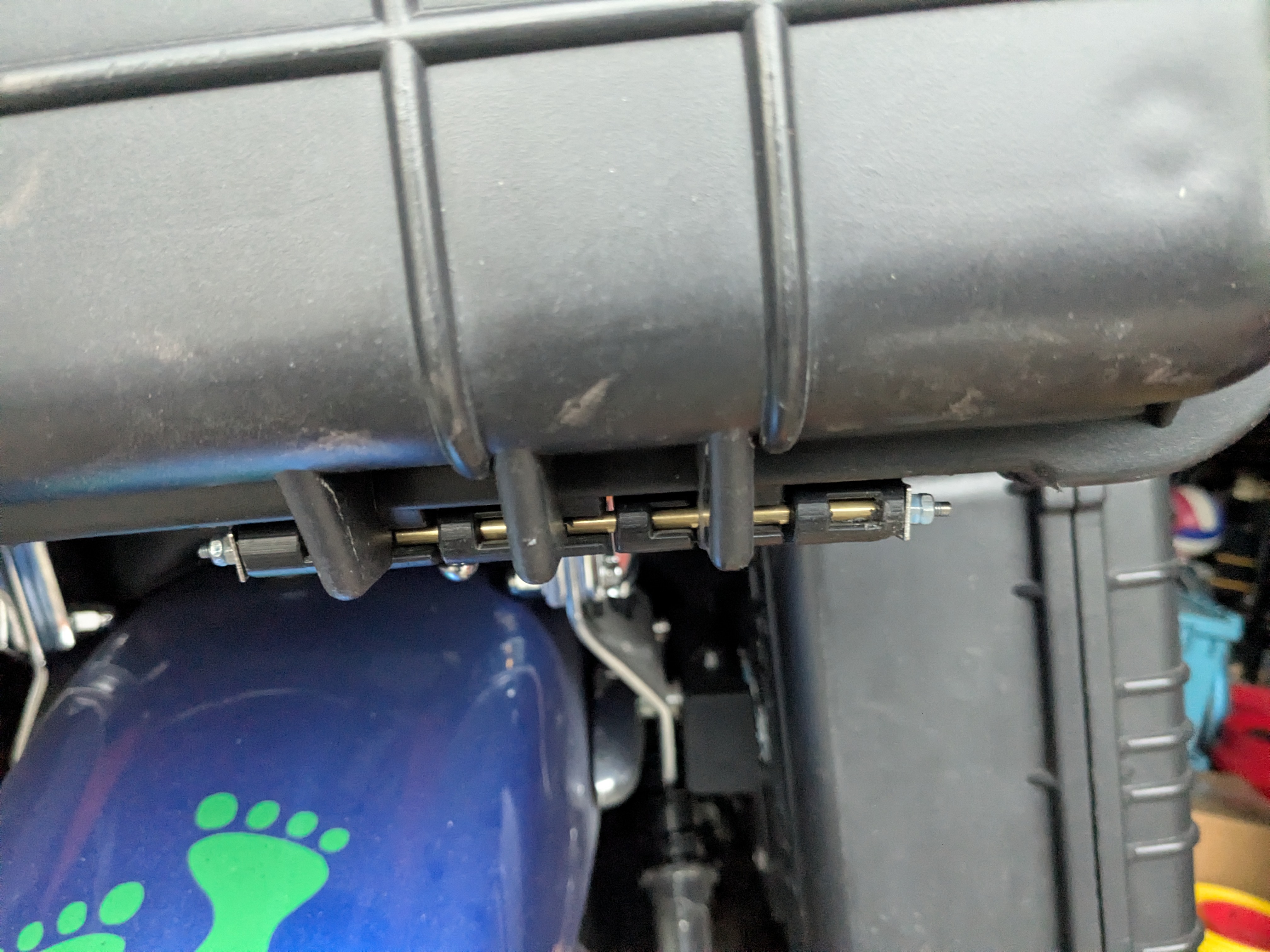 Final installed hinge pin retention setup with the brass tube, threaded rod, washers, and lock nuts in place