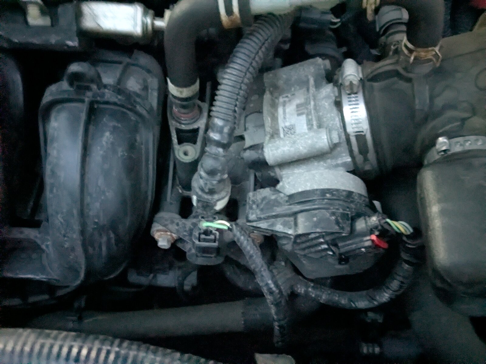 Photo of the electronic throttle body assembly in the engine bay, bolted to the intake manifold.